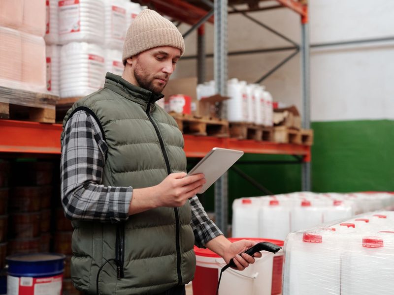 Lagermitarbeiter erfasst Ware mit Tablet und Barcodescanner