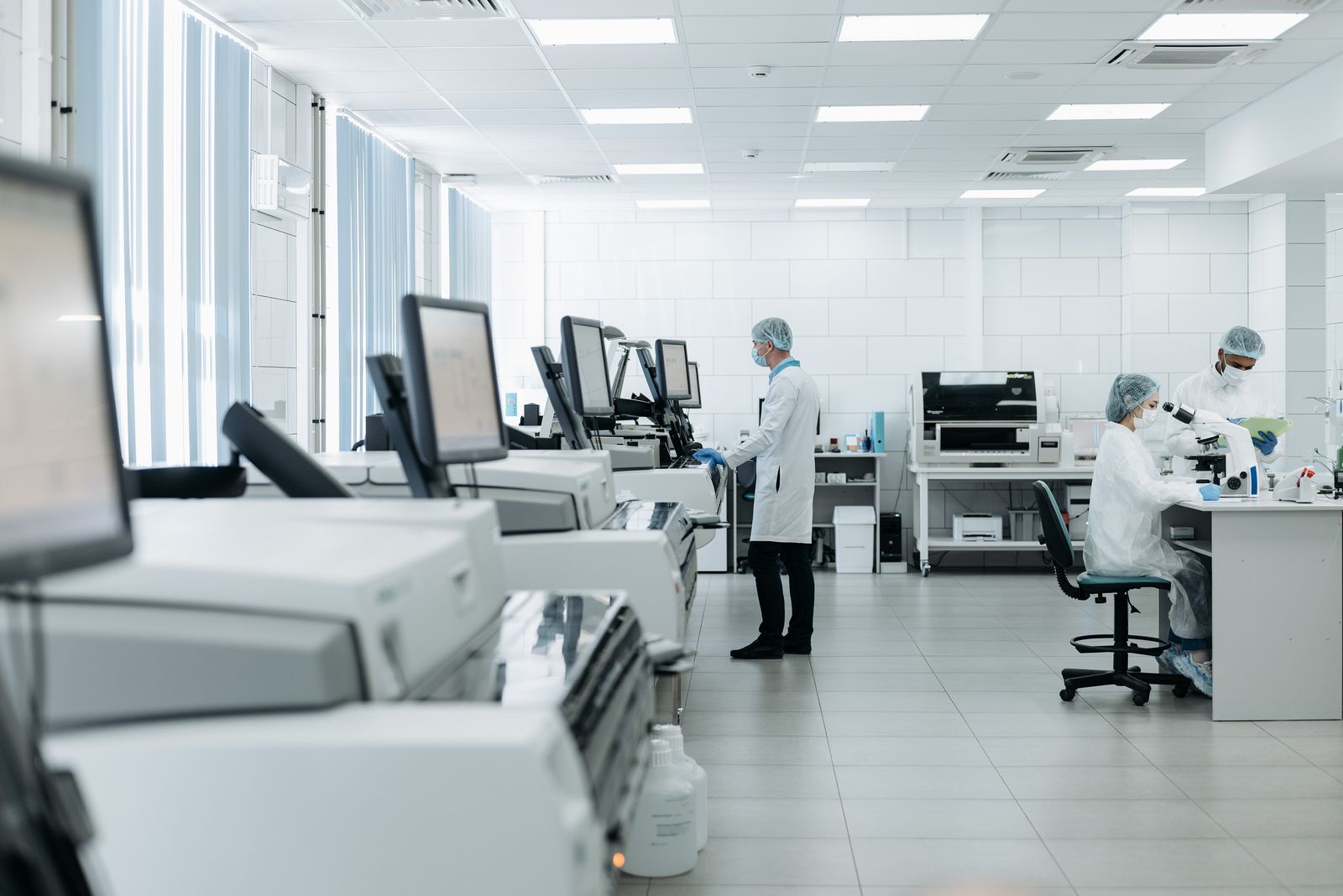 Laborfachkräfte arbeiten in moderner Laborumgebung mit technischen Analysegeräten