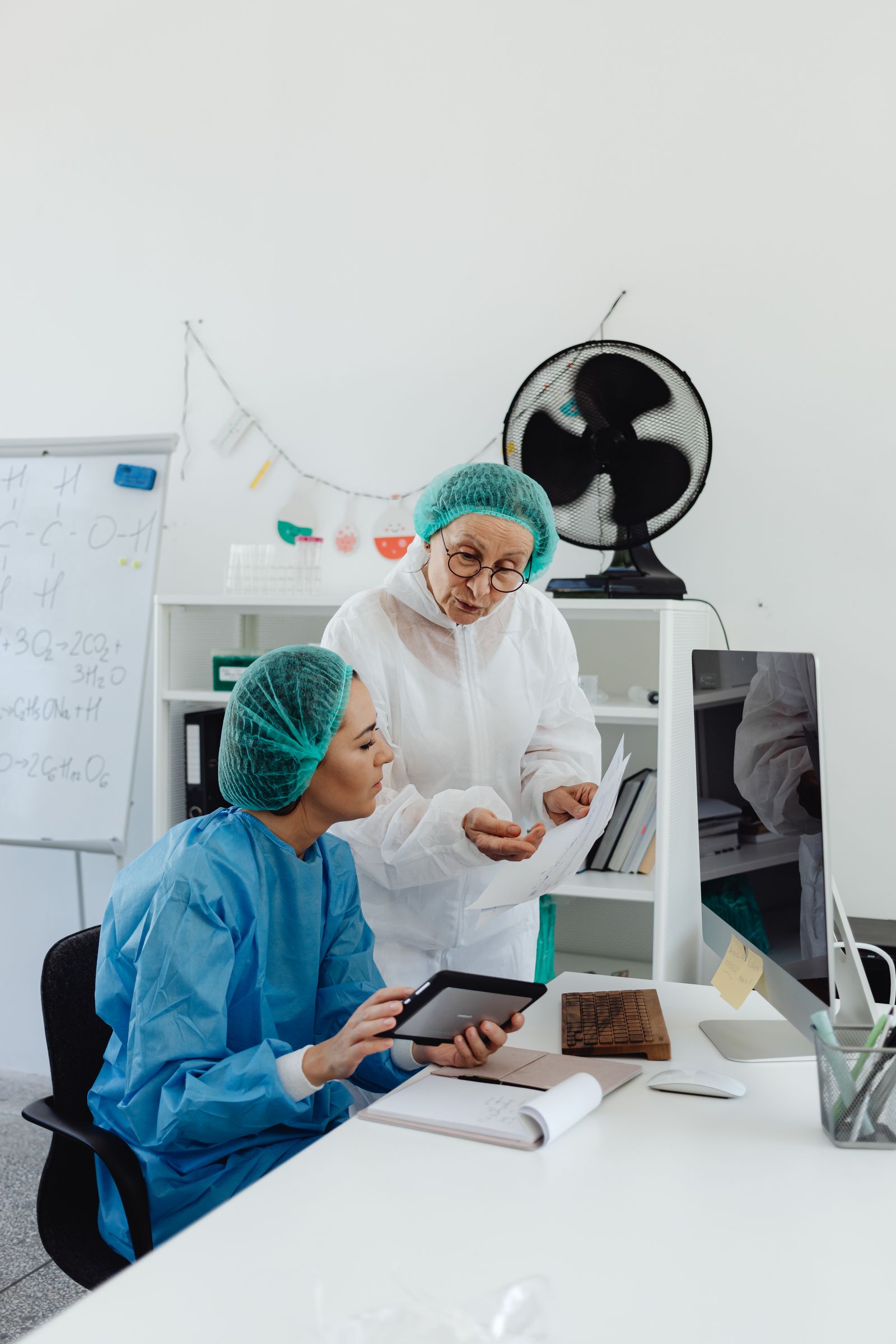 Laborfachkräfte arbeiten digital mit Tablet an technischen Analysegeräten