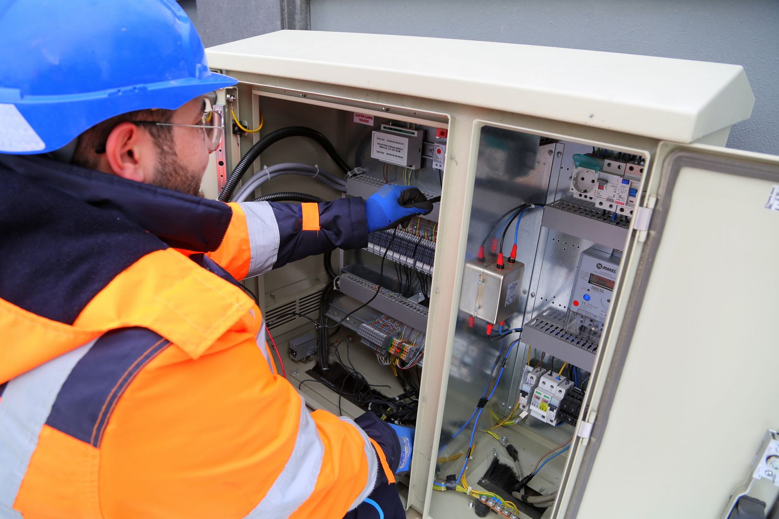 Servicetechniker arbeitet an einer elektrischen Anlage und dokumentiert den Einsatz